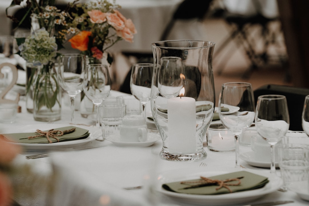 A decorated table setting with a lit candle and flowers.