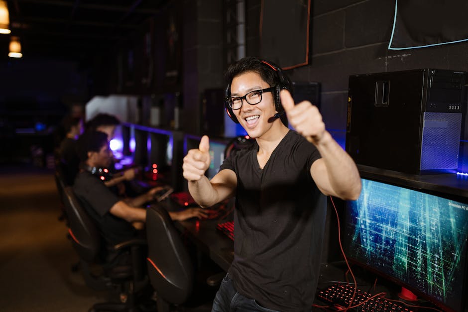 Happy gamer giving thumbs up in an esports gaming center with computers.