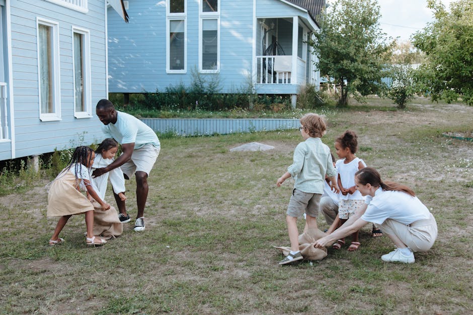 Children and adults play a sack race game in a backyard, showcasing diversity and fun.
