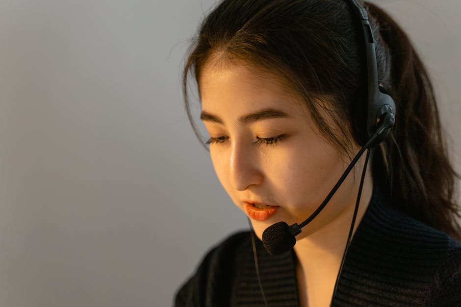 Focused young woman in headset working in customer support, speaking attentively.