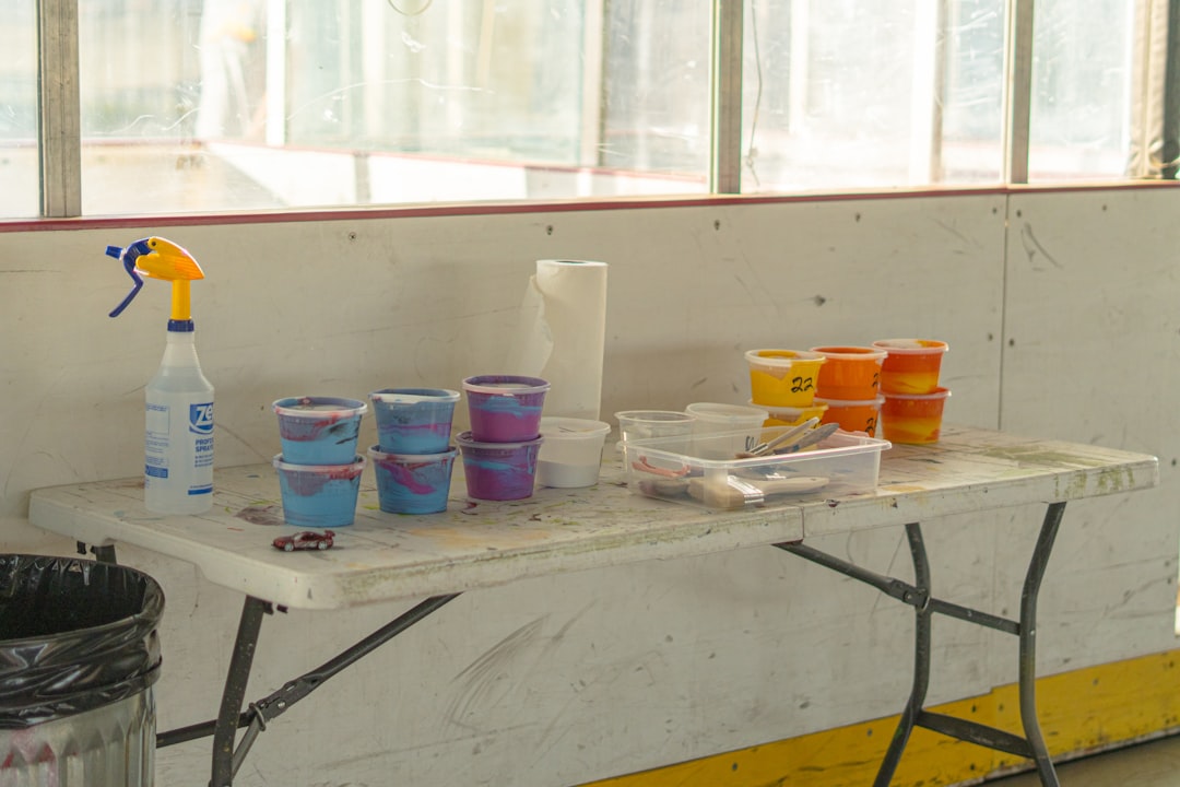 Paint supplies and spray bottles are on a table.